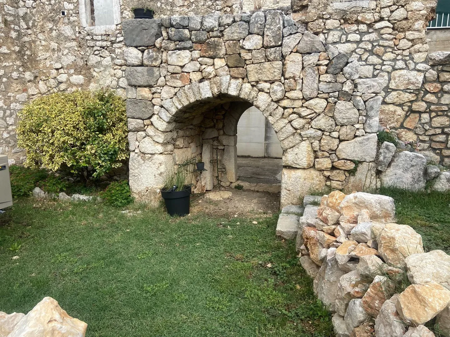 The ruin’s arch from the lawn, dry-stone walls in front