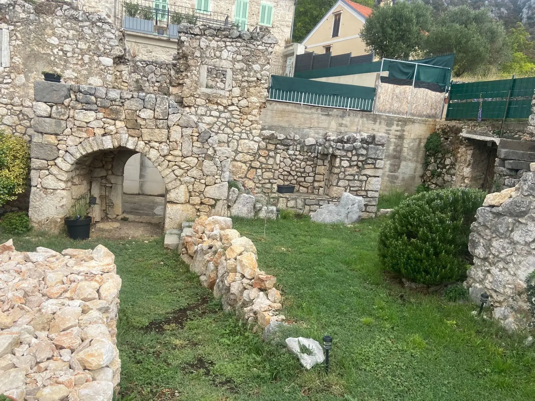 The ruin and its stone arch, in the grass