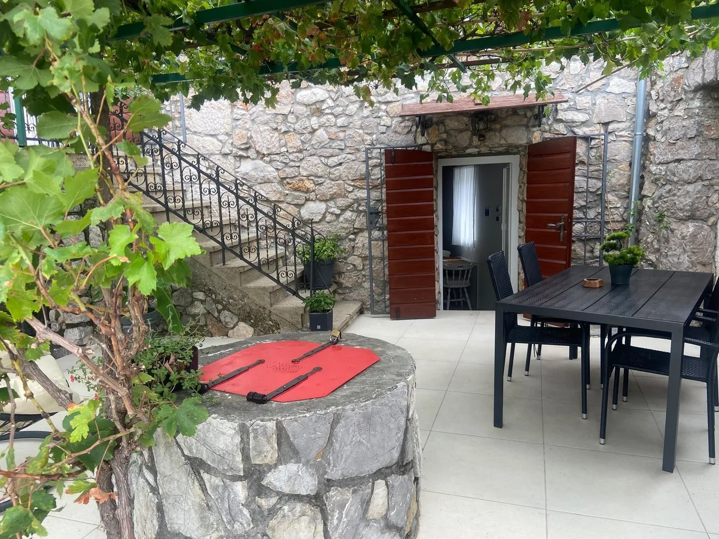The dining table on the terrace, the stairs to the first floor behind