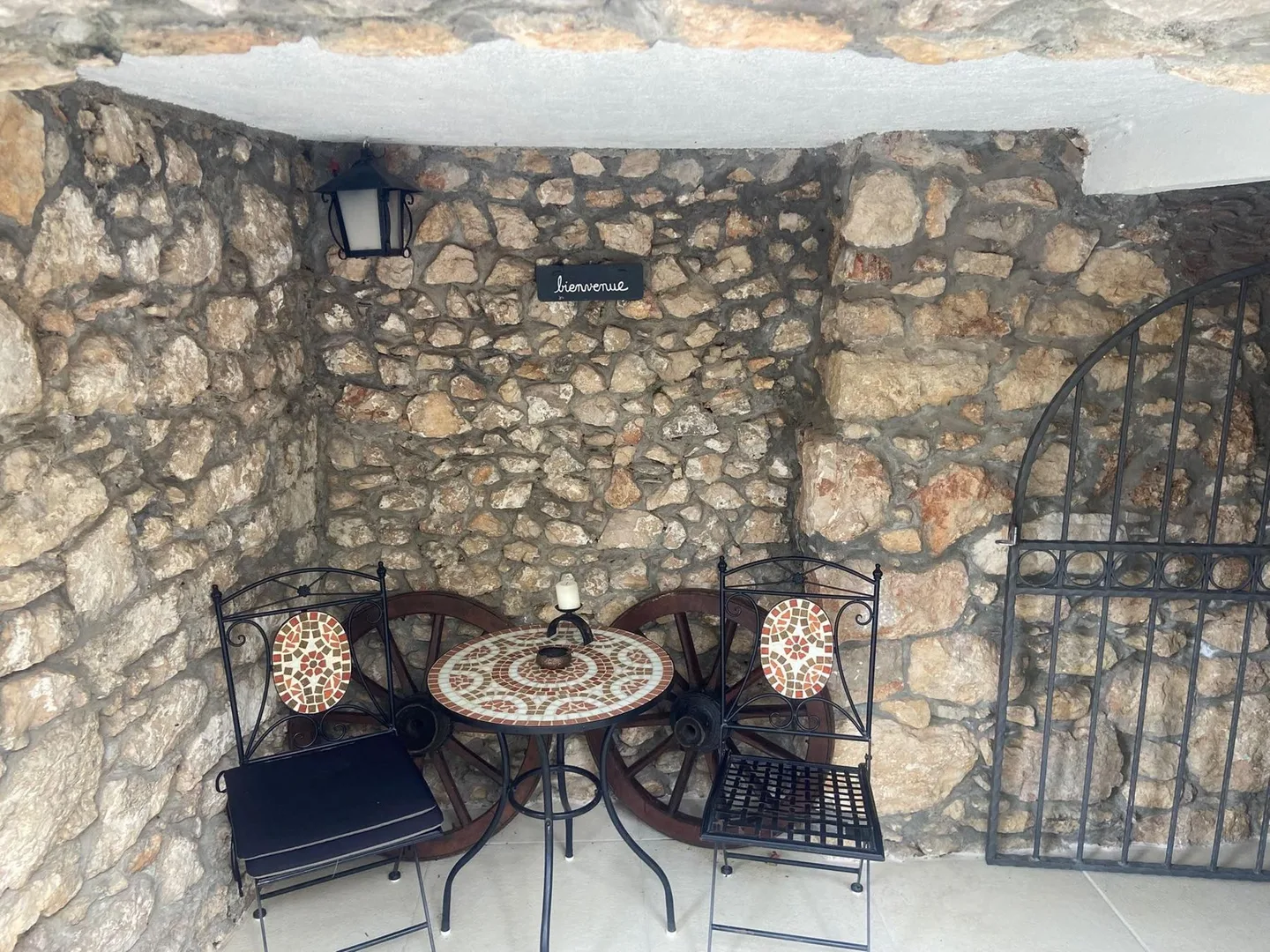 The bistro table in the alcove, a wrought-iron gate beside it