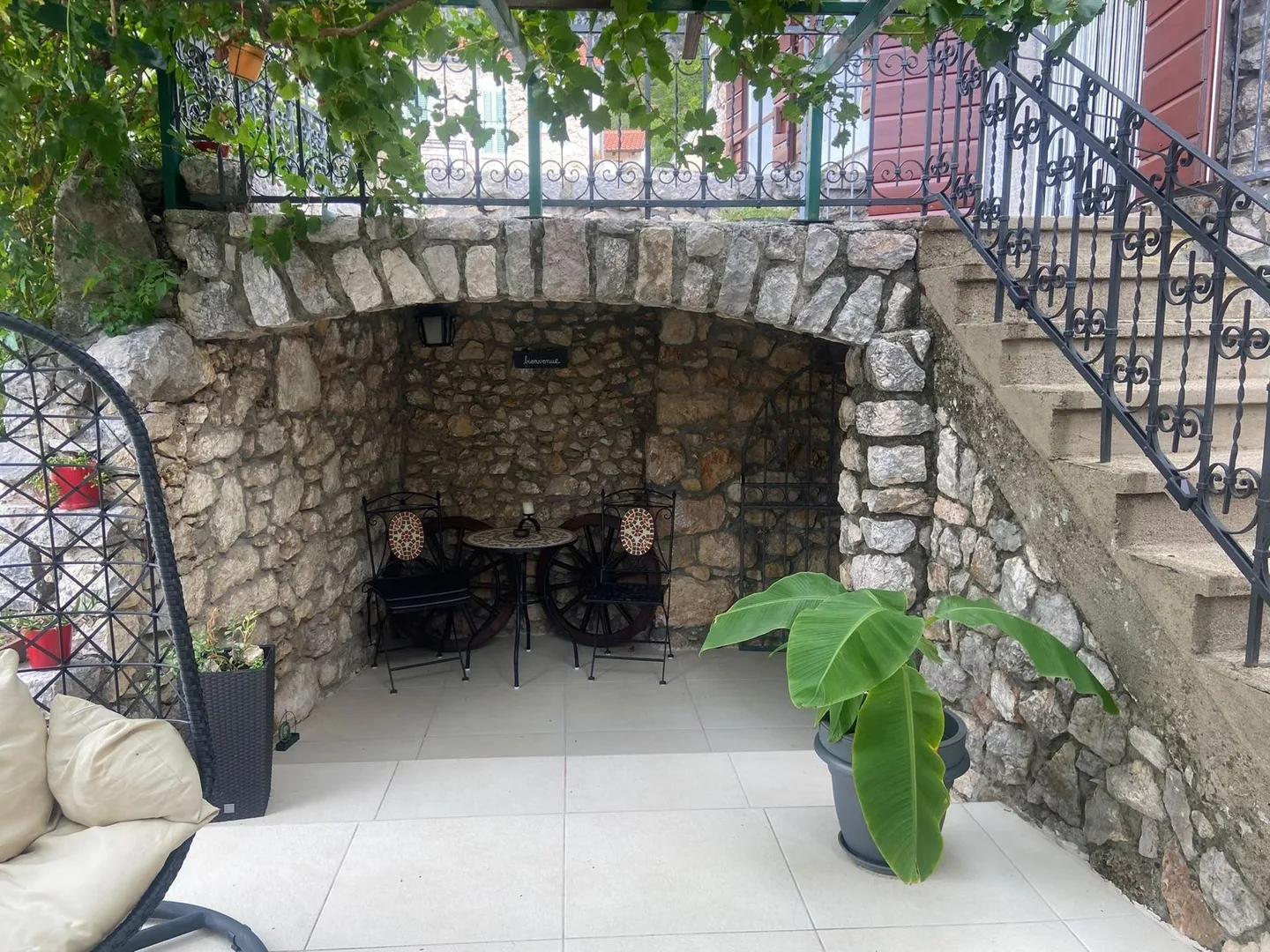 The alcove beneath the outside stairs, a plant in front