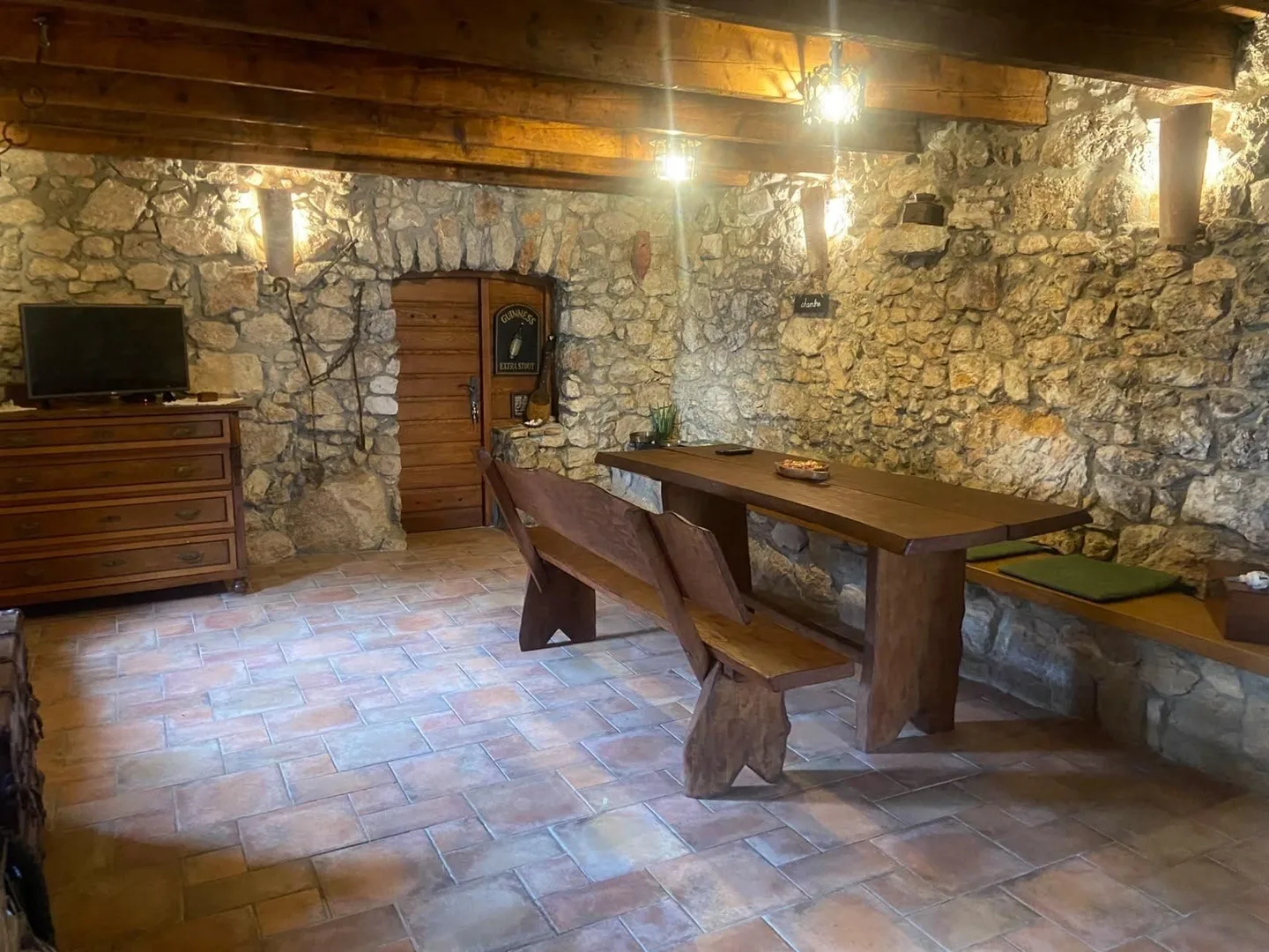 The konoba: stone walls, wooden beams and a long table