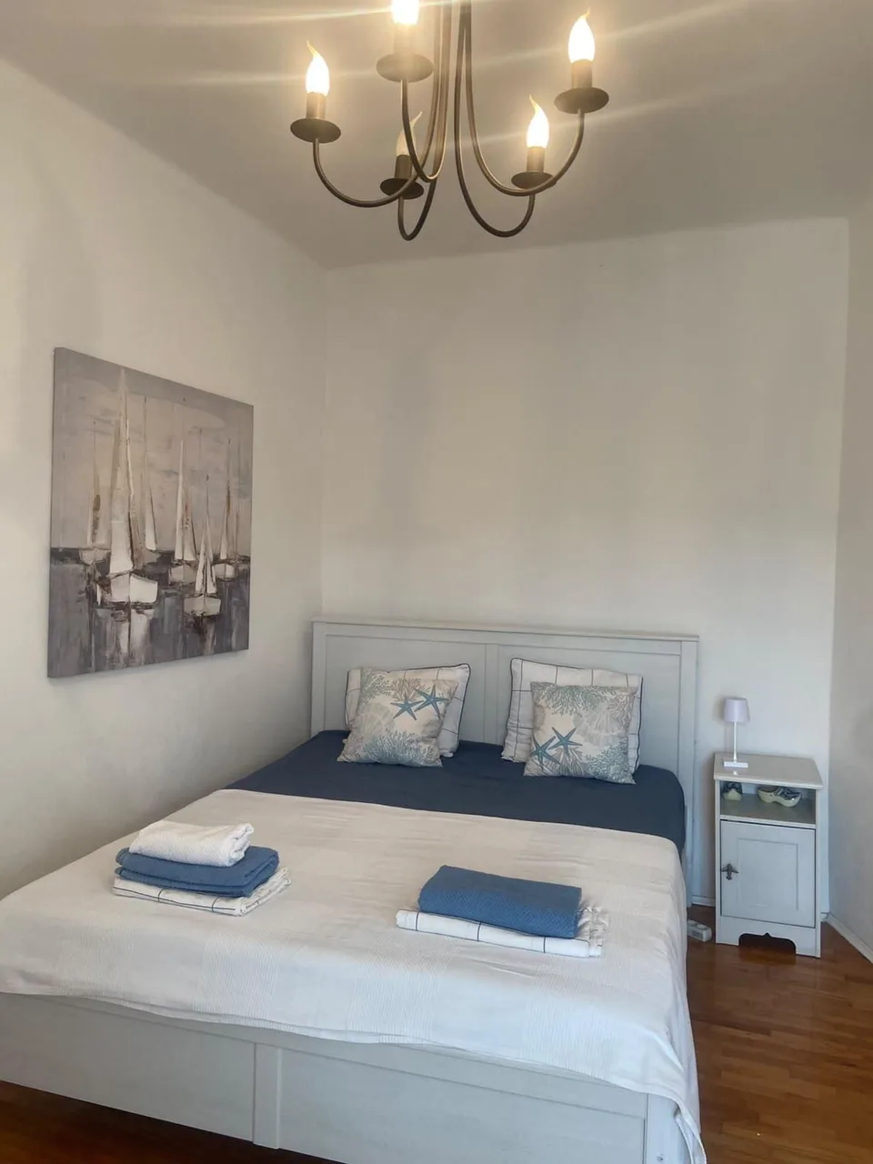 The bed made up with towels, sailing boats on the wall