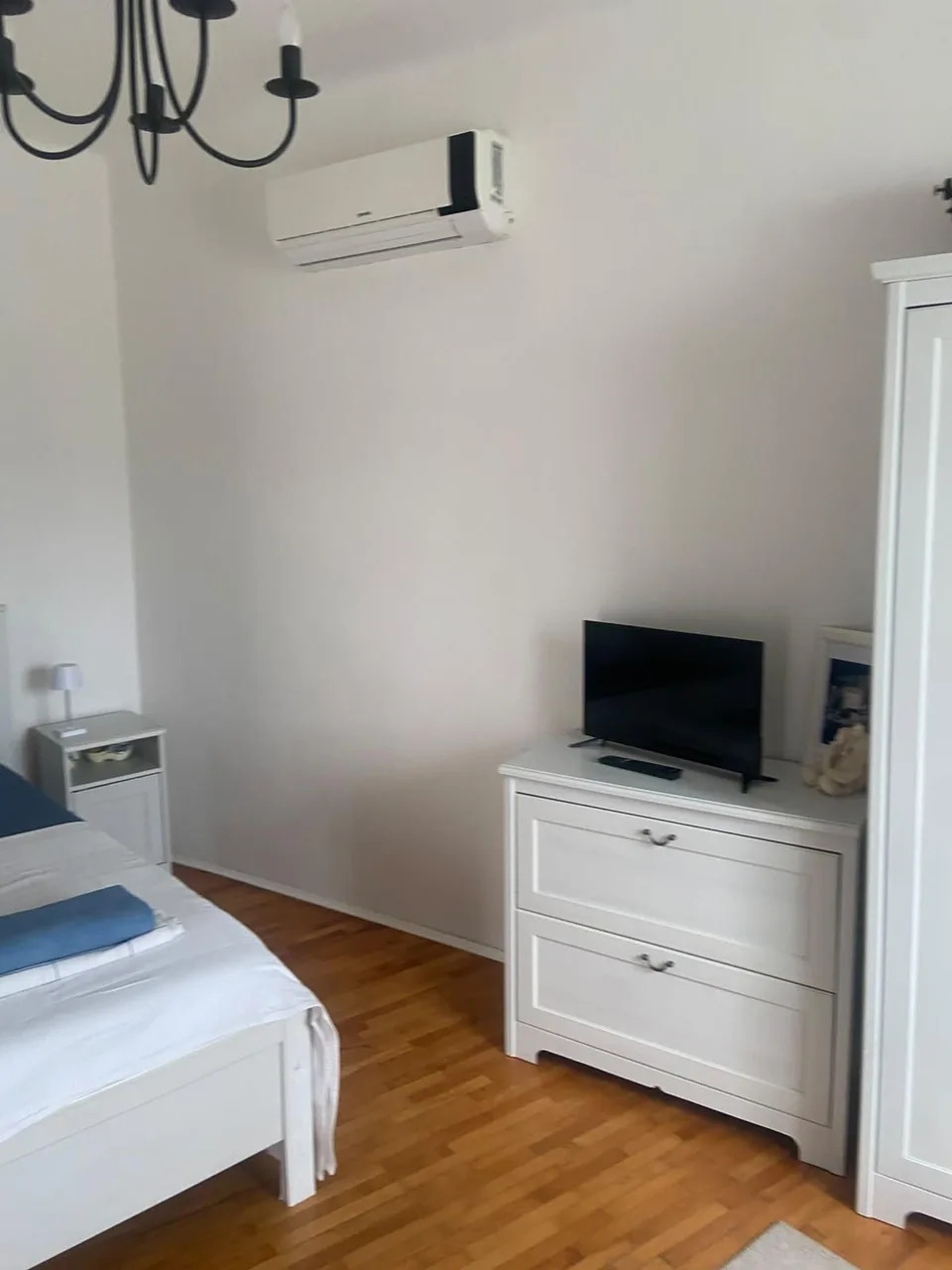 A white chest of drawers with a television
