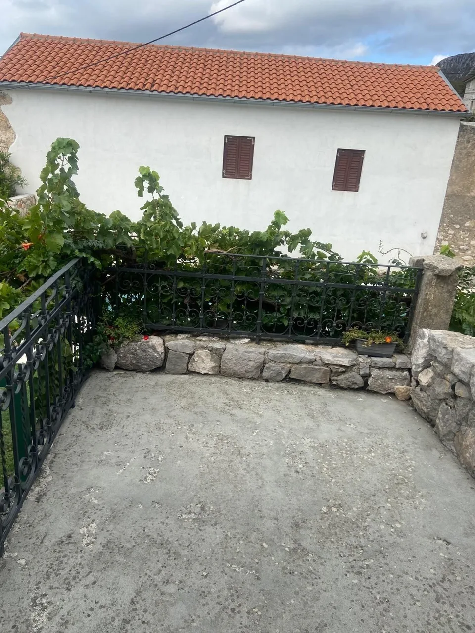 The balcony’s stone parapet and the white house next door
