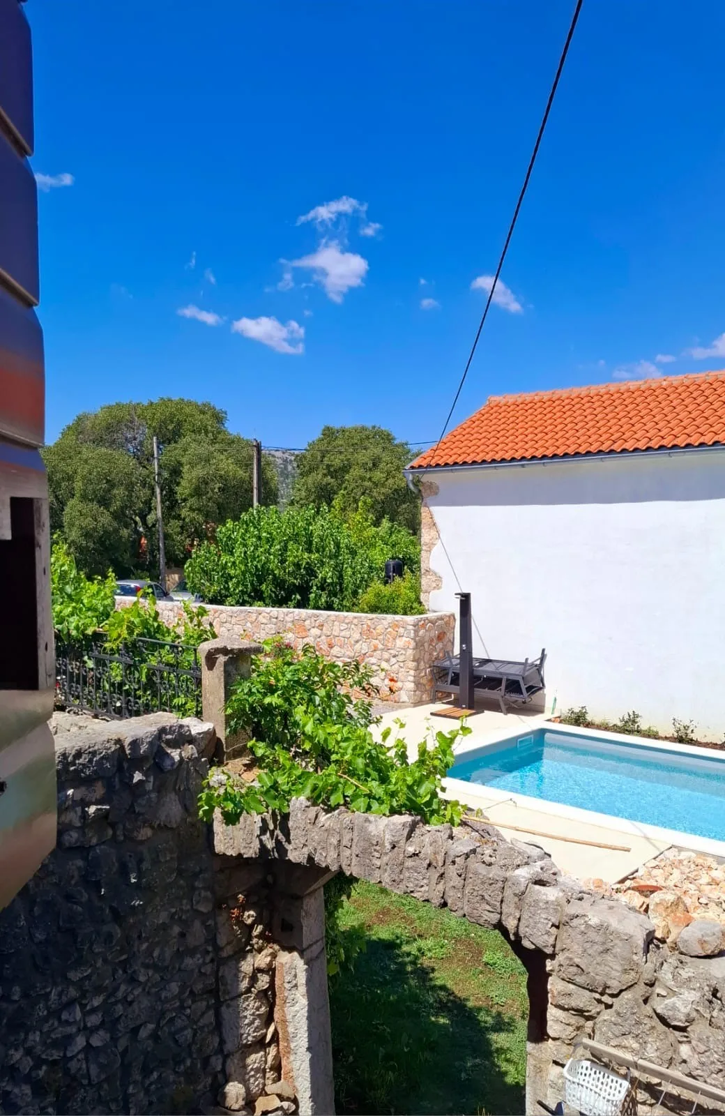 Looking down over the ruin’s arch, the vine on its wall and the pool beyond
